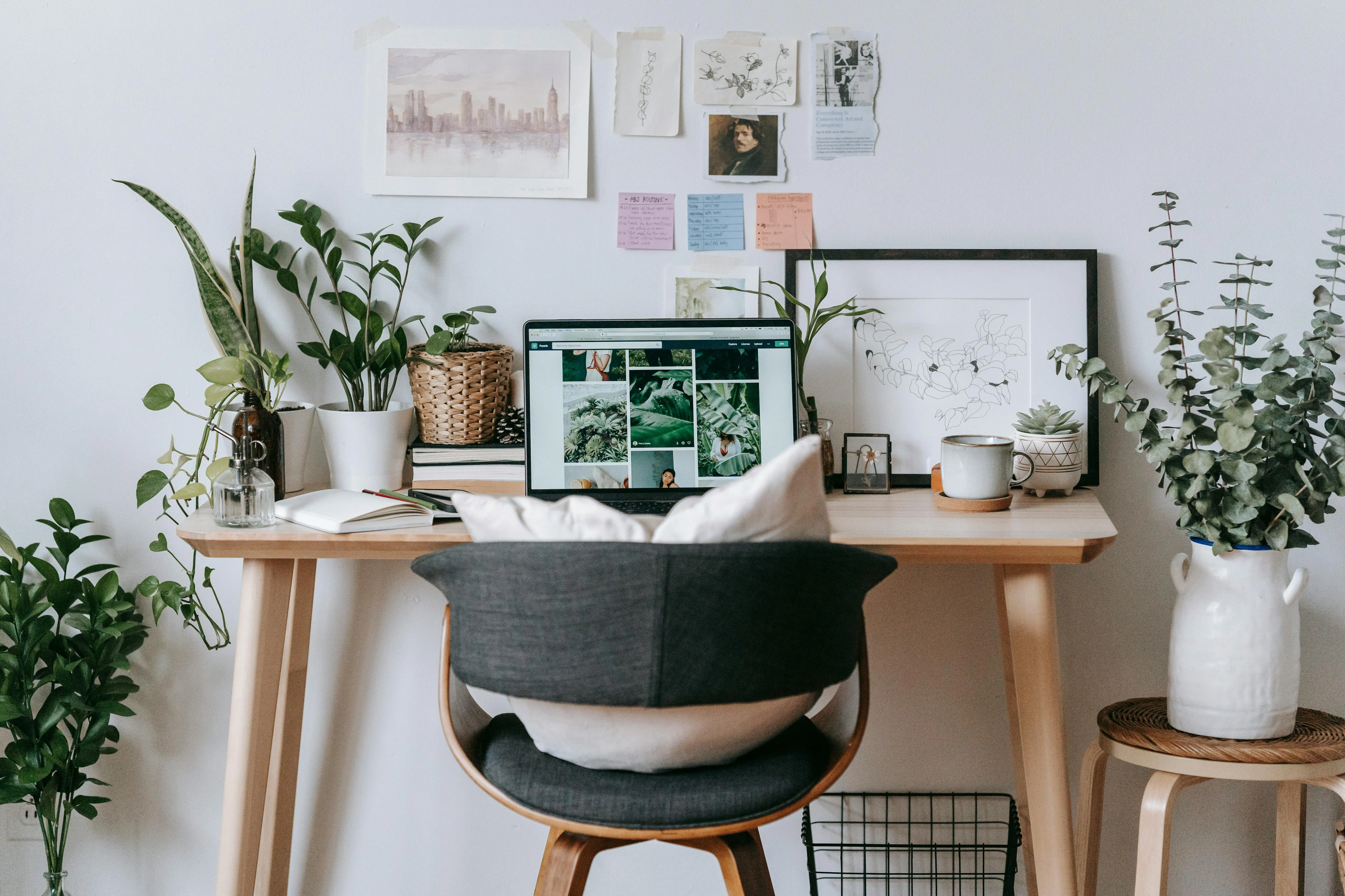 Calm home office desk with a laptop, plants, and natural light.